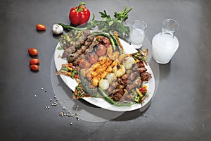 Lebanese Mixed Grill plate with arak  on a dark background