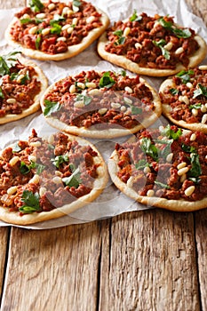 Lebanese Sfeeha meet pie or Lahm bi ajeen with ground beef, onions, tomato, and pine nuts closeup. vertical