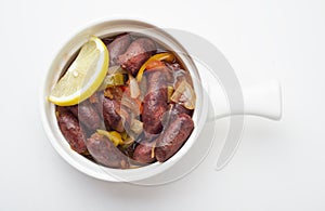 Lebanese starters of Sausage meat marinated, sausages fried in a metal pan isolated on white