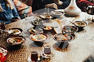 Lebanon cuisine served in restaurant. A young company of people is smoking a hookah and communicating in an oriental restaurant. T