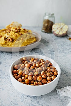 Leblebi Turkish delicacy of fried chickpeas in porcelain plate in kitchen, vertical food content, selective focus photo