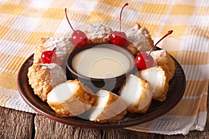 Leche frita and condensed milk, decorated with cherries close-up. horizontal photo