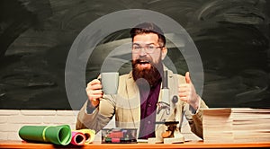 Lecturer in classroom. Handsome teacher relaxing. Teacher bearded man drinking tea chalkboard background. Relax concept
