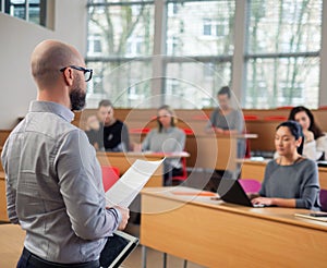 Lecturer and multinational group of students in an auditorium