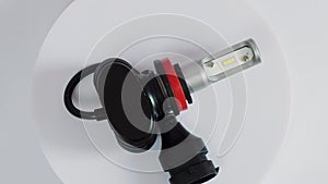 LED automotive lamp with electrical connector and cooling radiator rotates on a white background. Automotive part, macro