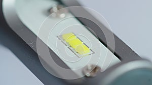 LED automotive lamp with electrical connector and cooling radiator rotates on a white background. Automotive part, macro