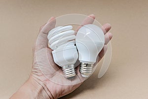 LED bulb and Fluorescent bulb on hand