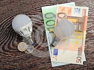 LED bulb and incandescent lamp at euro bills