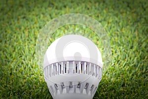 LED Bulb with lighting on the green grass
