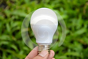 LED Bulb with lighting on green grass background