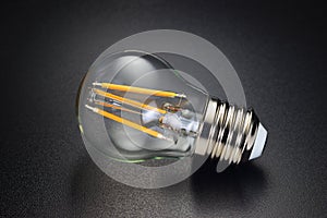 LED filament bulb on black