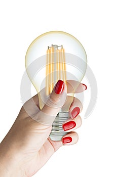 LED filament light bulb in female hand.