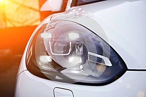 Led headlights of a white premium suv.  New generation of car light. Closeup of a hood and bumper