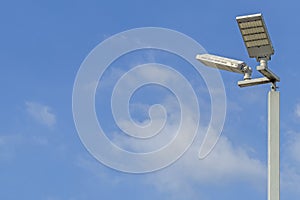 LED illuminated pole with a background of blue sky and clouds