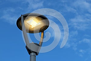 Led lamp glowing on blue sky and white clouds background