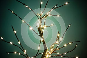 LED lamp tree against a green background. Luminous sparkling branches with many ramifications