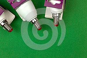 LED light bulbs with retail box, energy saving and eco friendly concept. Green background, flat lay, top view and copy