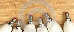 LED light bulbs, wooden table background. Energy saving, eco friendly concept. Frame, banner design, flat lay, top view