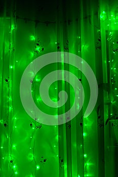 Led luminous garland with green lights on a dark background.