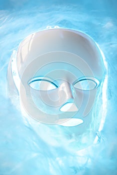 Led mask glowing blue on foggy background