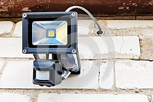 The LED motion sensor lamp is attached to the outer masonry wall