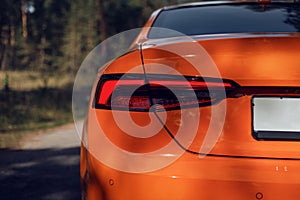 LED rear light. Detail on the rear light of a car. Modern orange color car. Car detail. Developed Car`s rear brake light