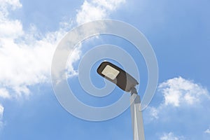 LED street lamp post glowing blue sky with white cloud background. Modern led lights in city