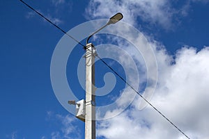 The LED street light is lined with a beautiful blue sky in the background with a video camera mounted on a pole. Video