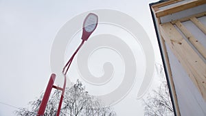 Led streetlight with red pole near building in winter park