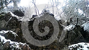 Ledge with icicles in picturesque winter wonderland scenery in dense snowfall