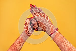 Ledy Feet and Hands in Heena for wedding in Orange and red background and isolated hand and feet