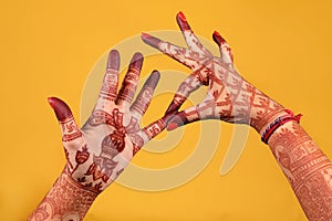 Ledy Feet and Hands in Heena for wedding in Orange and red background and isolated hand and feet