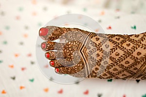 Ledy Feet and Hands in Heena for wedding in Orange and red background and isolated hand and feet