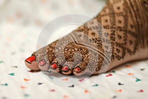 Ledy Feet and Hands in Heena for wedding in Orange and red background and isolated hand and feet