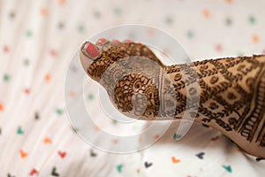 Ledy Feet and Hands in Heena for wedding in Orange and red background and isolated hand and feet