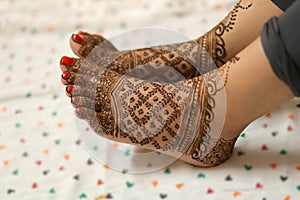 Ledy Feet and Hands in Heena for wedding in Orange and red background and isolated hand and feet