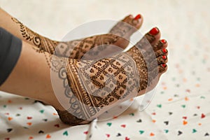 Ledy Feet and Hands in Heena for wedding in Orange and red background and isolated hand and feet