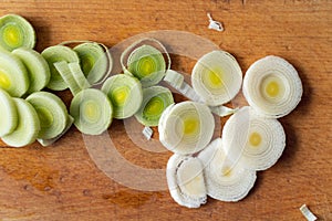leek slices on a wooden board, ready to prepare delicious soup