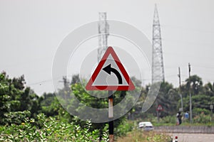 Left curve traffic sign on the side of National Highway Road