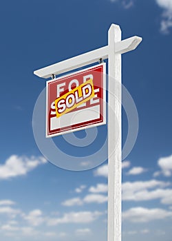 Left Facing Sold For Sale Real Estate Sign on a Blue Sky