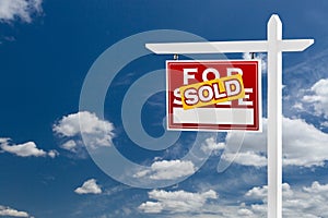 Left Facing Sold For Sale Real Estate Sign Over Blue Sky and Clouds With Room For Your Text.