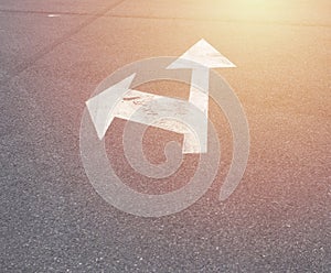 Left and forward arrow on the streer with sunrise light