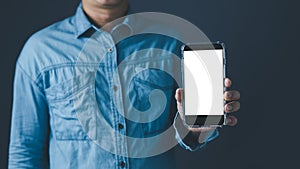 The left hand man showing a black smart phone or cellphone and a white screen display for mockup content at blue tone background