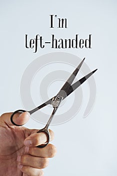 Left hand with scissors and text I am left-handed photo