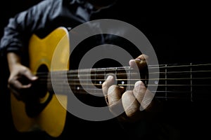 Left-handed focus of a guitarist holding an E major middle position