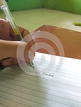A left-handed person who is writing with his left hand