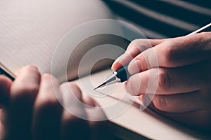 Left-handed woman writing diary