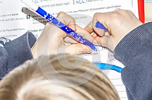 Left handed young doing his homework - Translation: read short time too pause sleeping burningif two consonants written photo