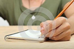 The left-hander writes in a notebook