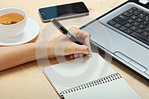 The left-hander writes in a notebook